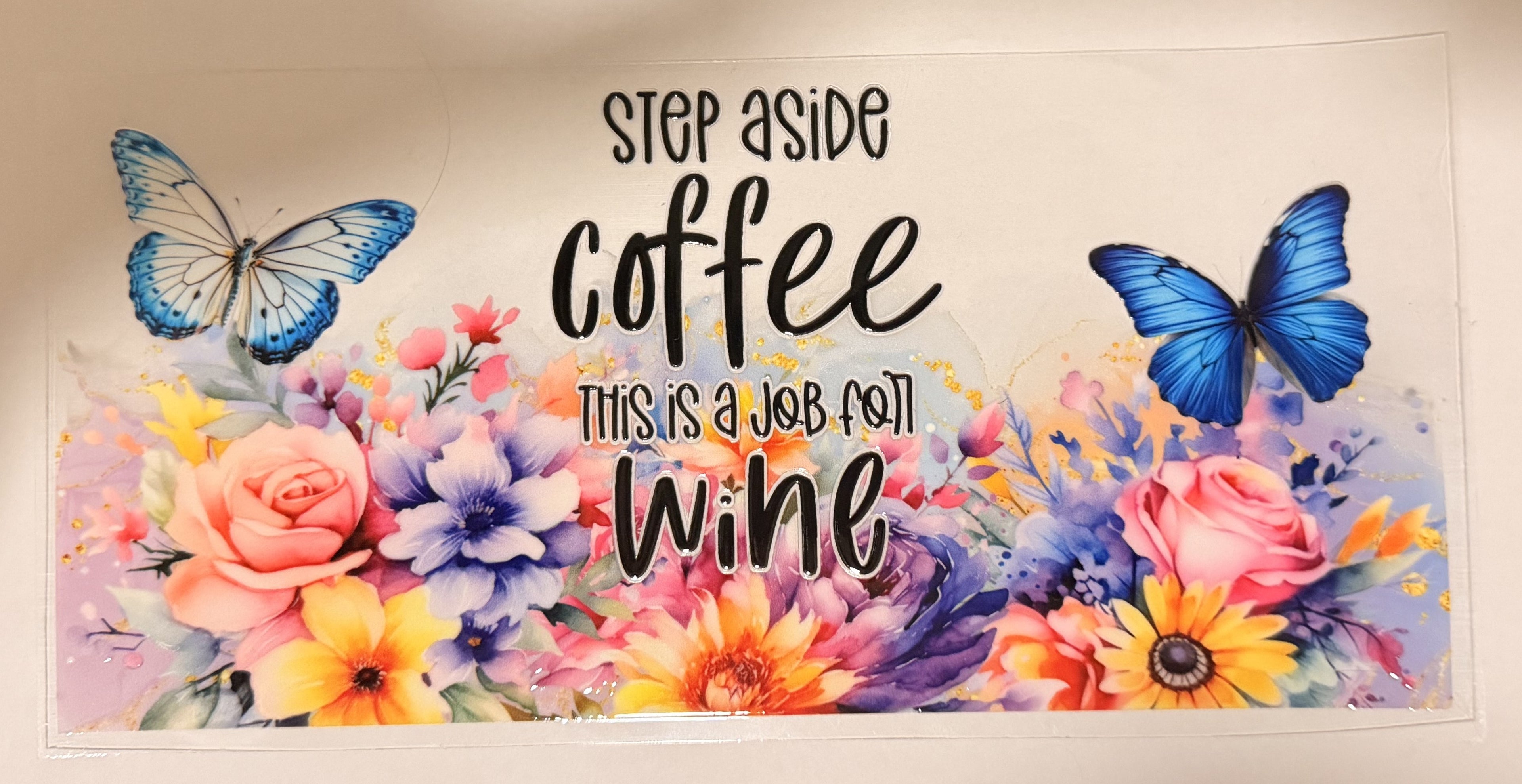 A rectangular wall decal or poster featuring colorful watercolor-style flowers and butterflies with the text 'STEP ASIDE coffee THIS IS A JOB FOR wine' in black lettering, shown against a plain light background.
