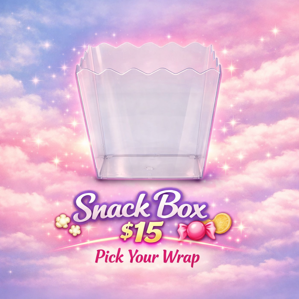 A clear plastic snack box centered on a pastel pink and purple cloud sky background with sparkles. Below the box, stylized text reads 'Snack Box $15 Pick Your Wrap' with candy graphics.